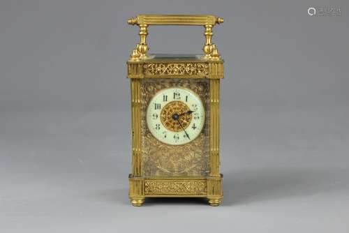 A French Brass Carriage Clock, having filigree panels, ivorine enamel face with numeric dial surrounded by a fretwork of floral tendrils and foliage, with four fluted columns and fluted carry handle, platform escapement with bevelled glass viewing platform, circa 1900, approx 8 x 6