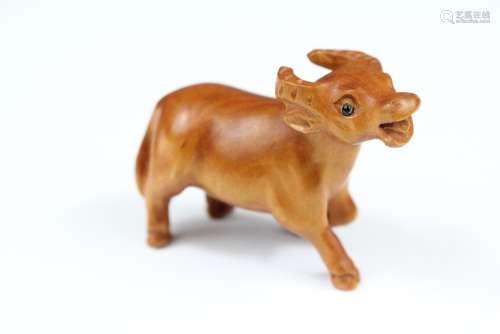 A Boxwood Netsuke, in the form of a Yak, with glass eyes, with character marks to base, approx 50 x 40 mm
