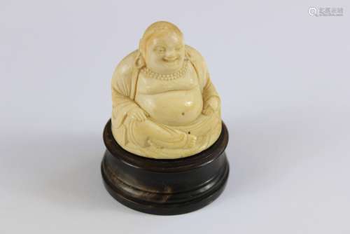 Antique Ivory Carved Netsuke depicting Buddha seated in the Lotus position, approx 6 cms h, supported on a circular horn plinth