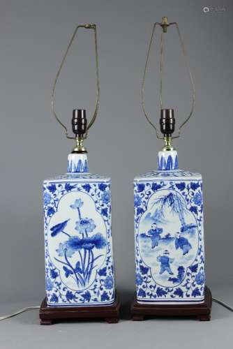 Two Chinese Blue and White Ceramic Lamp Bases; the bases depicting figures in a garden, supported on wooden stands, approx 41 cms base to fitting