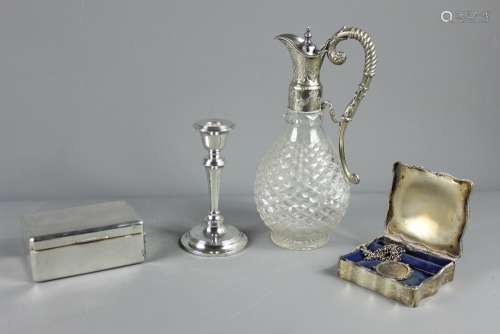 Silver and Silverplate - This lot comprises silver candlestick, Chester hallmark, dated 1909, mm S B & S Ltd together with a silver double cigarette box, approx 14 x 9 x 5 cms, Birmingham hallmark (rubbed) a silver trinket box Birmingham hallmark, 1938, mm Zimmermann and a cut-glass silver plated claret jug