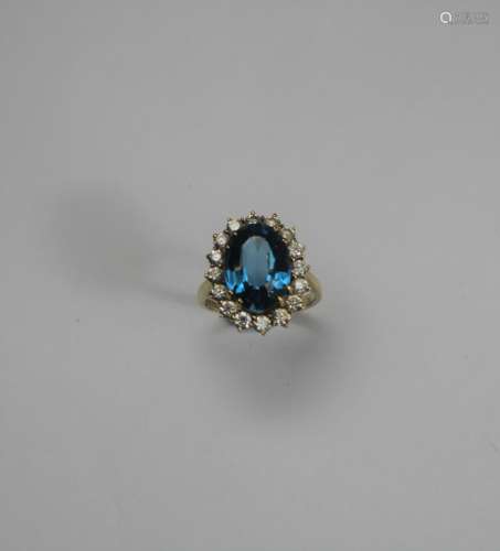 A Bespoke 9ct Yellow Gold Blue Topaz and White Stone Ring, the ring set with a sea-blue topaz approx 14 x 10 mm, with sixteen 2
