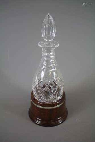 A Cut Crystal Decanter, supported on a polished oak stand with silver banded rib, London hallmark, dated 1989, mm Pierce Hart