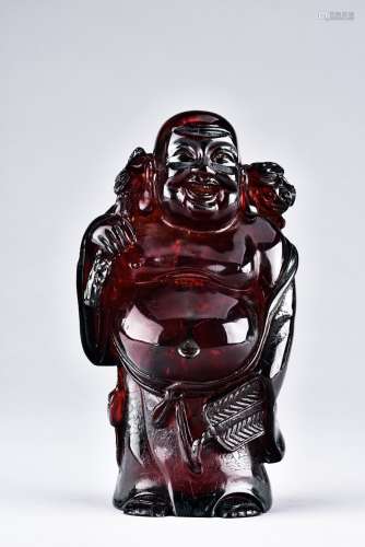 AN AMBER CARVED ARHAT FIGURE