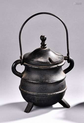 A BRONZE HANDLED TRIPOD VESSEL