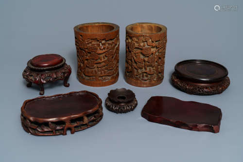 Two Chinese carved bamboo brush pots and five wooden stands, 19th/20th C.