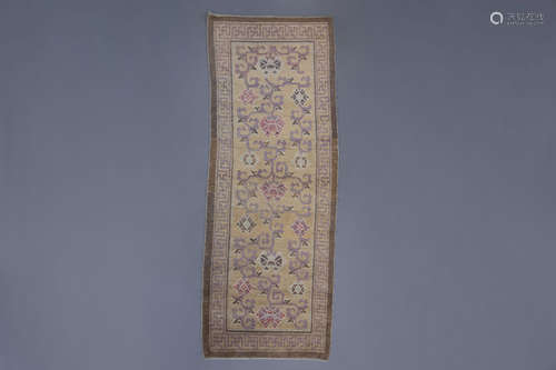 A long Chinese carpet with stylised flowers, 19th C.