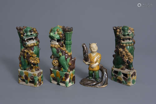 Three Chinese famille verte biscuit models of Buddhist lions and a figure of a boy, Kangxi and later