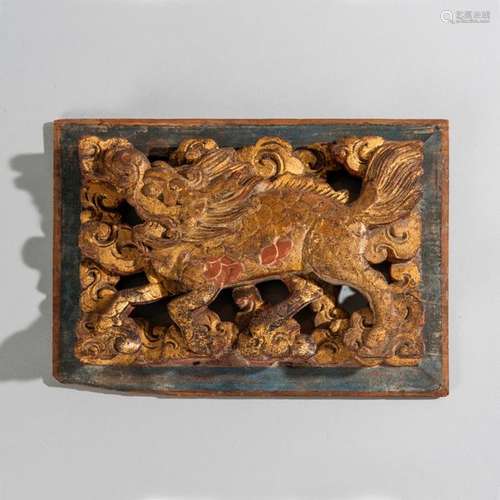 Bas relief en bois laqué figurant un qilin parmi l…