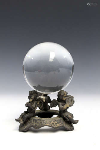 Glass ball on bronze stand.