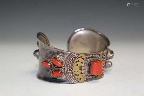 Silver bangle with red coral decorations.