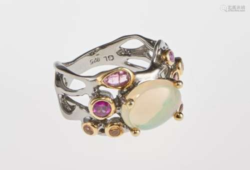 Bague sertie d'une opale ovale taille cabochon entourée de pierres de couleur - [...]