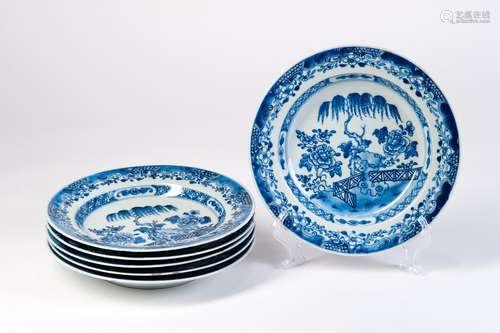 A GROUP OF BLUE AND WHITE DISH WITH FLOWERS IN GARDEN