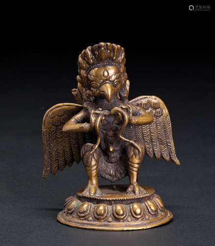 A CARVED COPPER FIGURE OF EAGLE FACE BUDDHA