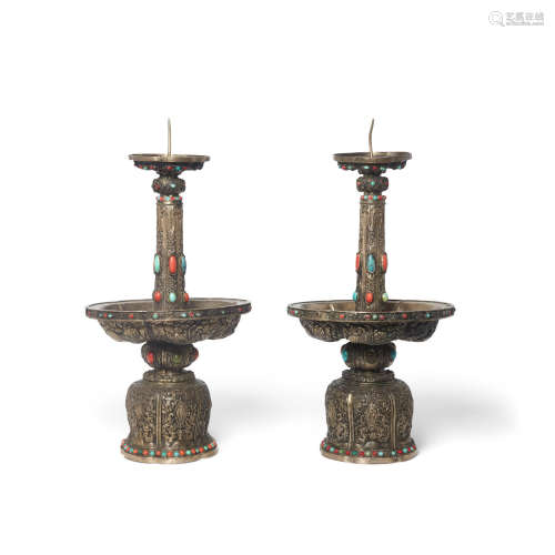 A pair of Mongolian metal and stone mounted candle prickets