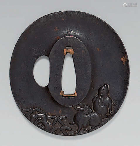 Slightly concave iron Tsuba with relief decoration…