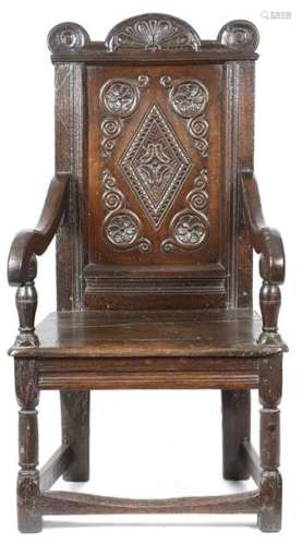 A 17th century oak panelled back armchair, with a …
