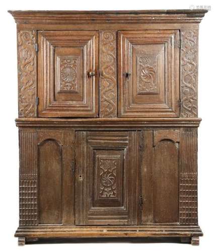 An oak cupboard, with two hinged doors with carved…