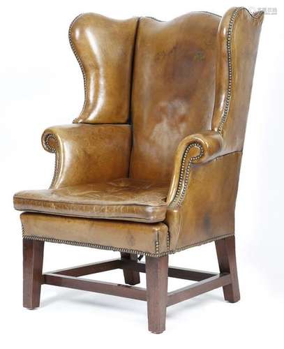 A mahogany wing armchair in George III style, upho…