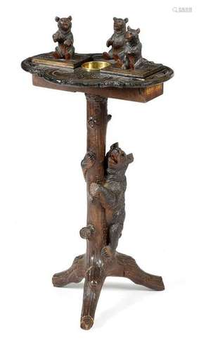 A Black Forest carved wood smoker's table, the nat…