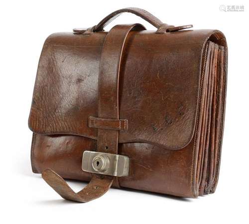 A brown leather briefcase, the cover stamped with …