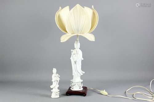 A Chinese porcelain lamp base, modelled as Guanyin, approx 31 cms h, heightened with a lotus-blossom lampshade, together with a small white porcelain figurine depicting Guanyin, approx 18 cms h