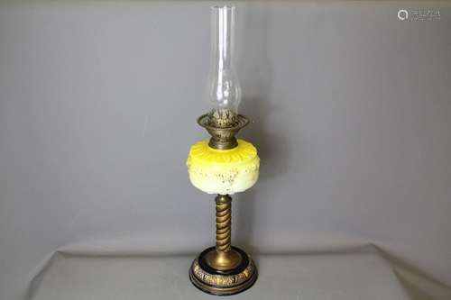 A Victorian acid yellow oil lamp; the lamp having a bright yellow oil reservoir, on black and gilt base, glass chimney, approx 66 cms overall