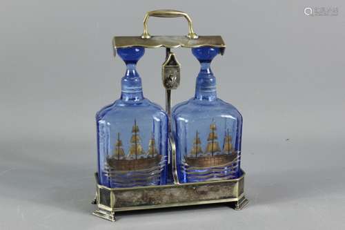 A tantalus comprising two blue glass decanters with a nautical theme in a silver plated frame, approx 22 x 10 x 28 cms