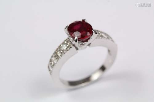 An 18ct white gold ruby and diamond ring, the ring set with an oval pigeon's blood ruby approx 7 x 6mm and approx 30 pts of dias to the shoulders, size I, approx 5