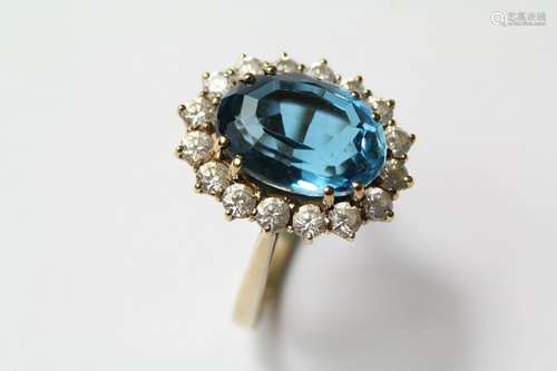 A Bespoke 9ct Yellow gold blue topaz ring, the ring set with an opal topaz approx 14 x 10 mm, surrounded by sixteen cz approx  2