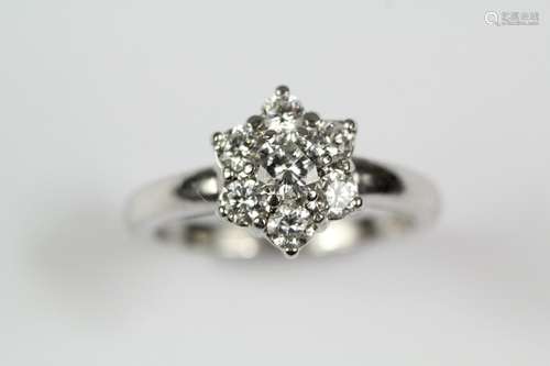 An 18ct white gold diamond cluster ring, set with a center stone approx 20 pts and six further stones of 6 pts, size L, approx 4