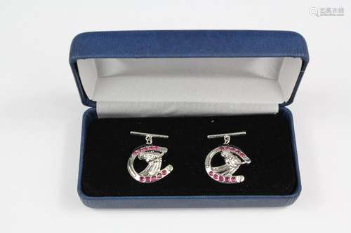 A pair of silver and ruby horseshoe cufflinks