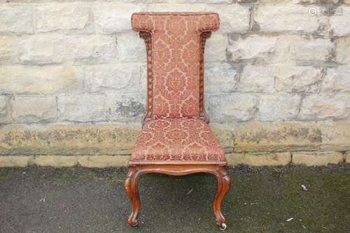 Antique Prayer Chair; the chair having wine-coloured embossed fabric covering, carving to side supports, cabriole legs on casters, approx 47 x 47 x 91 cms