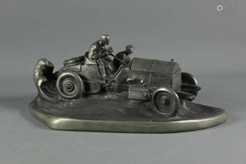 Early 20th century pewter inkwell; the inkwell in the form of a racing car with two men, the bonnet opens to reveal a well for the ink, approx 38 x 20 cms