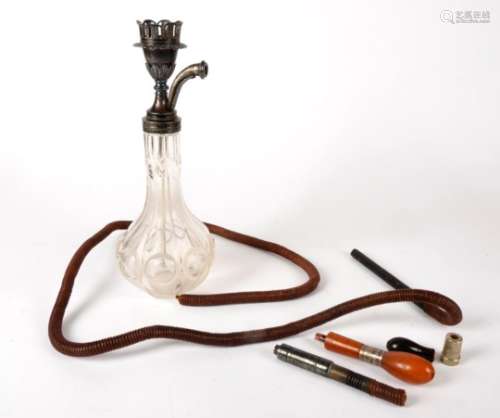 A Middle Eastern hookah pipe, with cut glass reservoir, the white metal top decorated with foliate