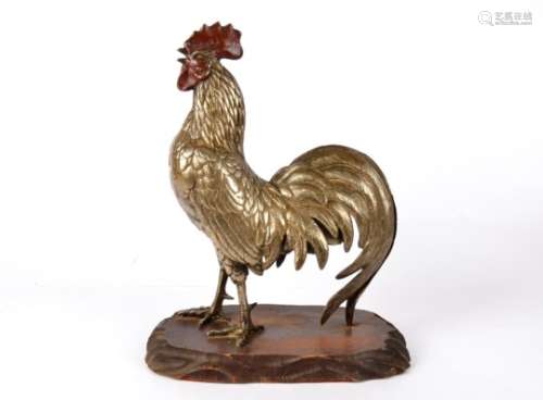 A white metal figure of a cockerel, with painted highlights, standing upon a wooden base, height