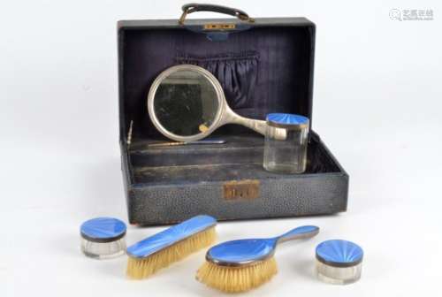 A hallmarked silver and blue enamel dressing table set, in a case, including two brushes, a