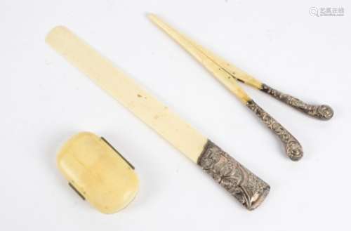 An antique metal mounted ivory purse with red liner, together with two silver mounted ivory tools,