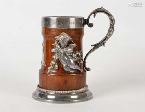 A silver plated and mahogany tankard, the body with two mounted metal putti wrapped in swathes of