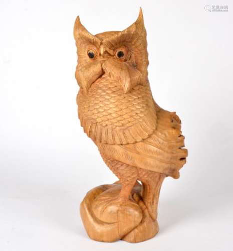 A large hardwood carved model of a tawny owl, the carved body on a naturalistic base with black