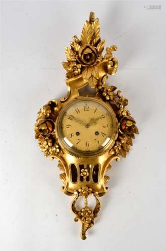 A carved Swedish clock, with highly ornate giltwood surround in the form of flowering plants, the