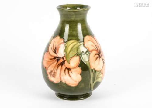 A William Moorcroft pear shaped vase, tube lined and decorated in the 'Hibiscus' pattern against a