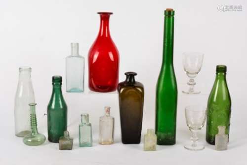 A collection of antique glass bottles, assorted shapes, sizes and colours, some with brewery and