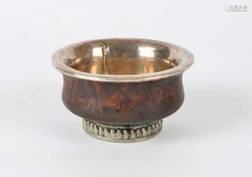 A Tibetan hardwood bowl, with white metal interior and footrim, height approximately 5cm, diameter