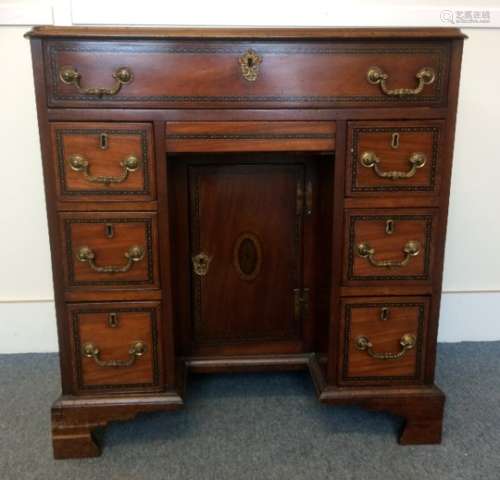 A 19th Century mahogany kneehole desk, one long drawer above the central panelled door and drawer,