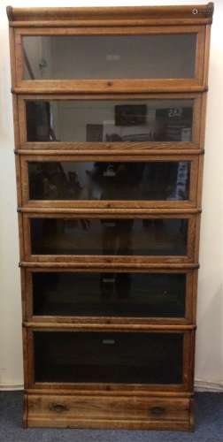 An oak globe wernicke bookcase, six sections with glazed up and over doors and metal trimmings, with