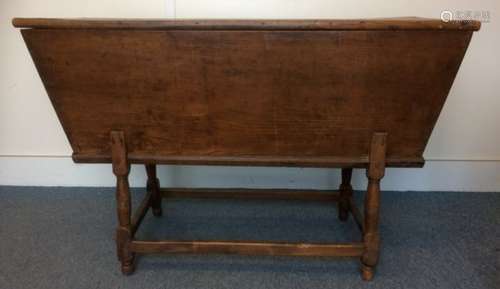 An antique elm dough bin, on turned supports united by rectangular stretchers, lift up top revealing