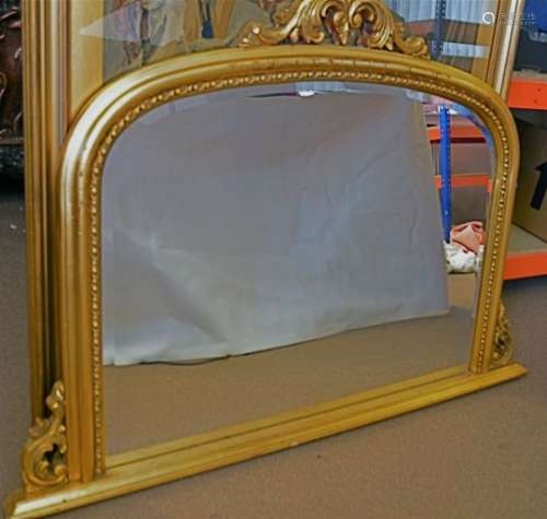 A contemporary gilt over mantle mirror, of arched form with applied scroll brackets and top, 92cm
