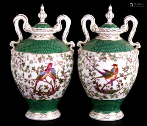A pair of continental two-handled urns and covers decorated with birds amongst foliage, 28cms (
