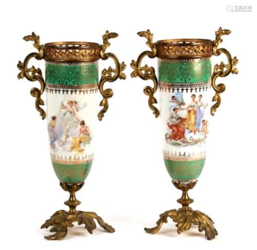 A pair of continental porcelain vases with gilded mounts, decorated with maidens and cherubs, signed